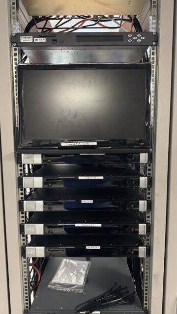 Rack of broadcast processing units with a Tandberg unit and monitor